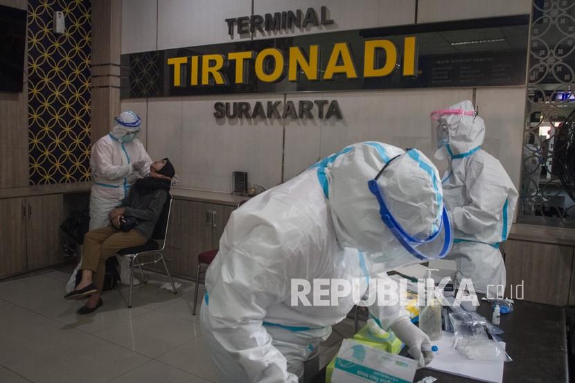 Petugas medis mengambil sampel lendir penumpang bus untuk tes usap atau Swab Antigen di Terminal Tirtonadi, Solo, Jawa Tengah