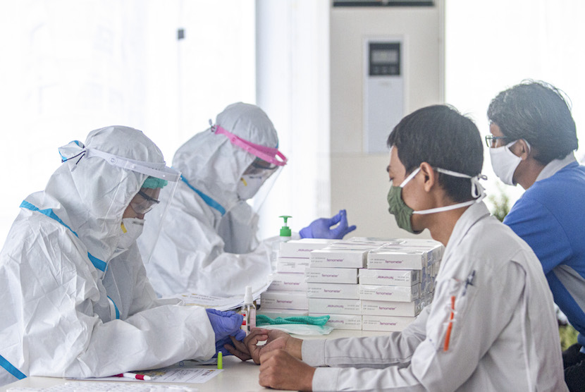 Petugas medis mengambil sample darah buruh saat tes diagnostik cepat COVID-19 di kawasan Suryacipta, Karawang, Jawa Barat, Selasa (23/6/2020).  