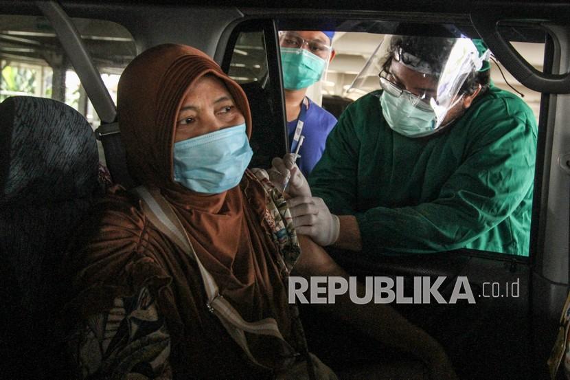 Petugas medis menyuntikan vaksin kepada lansia secara drive thru di Rumah Sakit Universitas Indonesia, Depok, Jawa Barat. Dinas Kesehatan (Dinkes) Kota Depok terus melakukan peningkatan capaian vaksinasi Covid-19 lansia, dengan melakukan jemput bola bagi lansia yang ada di Kota Depok.
