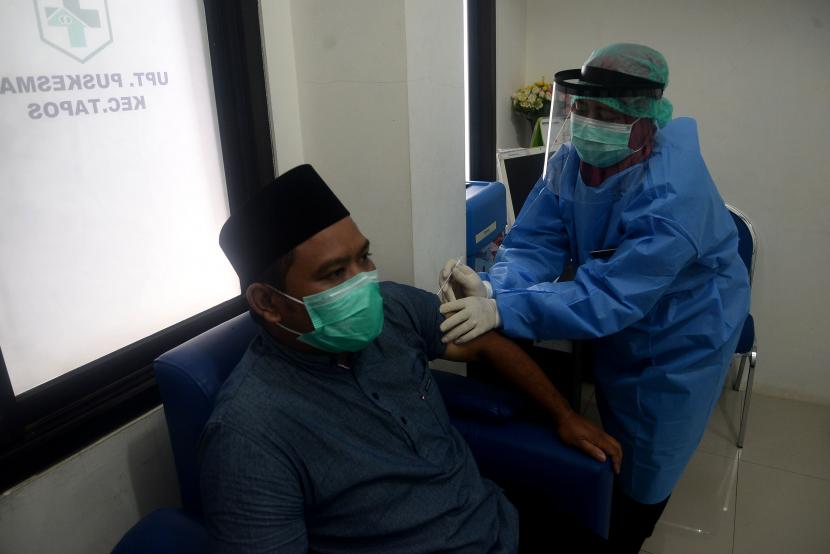Petugas medis menyuntikan vaksin warga saat proses simulasi uji coba vaksinasi Covid-19 di Puskesmas Tapos, Depok, Jawa Barat.