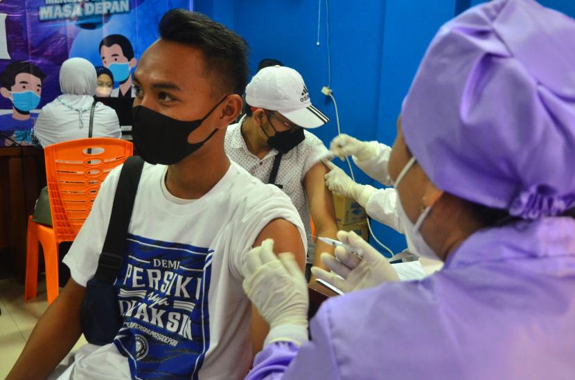 Petugas medis menyuntikkan vaksin COVID-19 kepada pemain sepakbola Persiku Kudus di GOR Bung Karno, Kudus. Pemerintah menyebut Indonesia berada peringkat tujuh negara sebagai vaksinasi Covid-19 secara kumulatif tertinggi di dunia. 