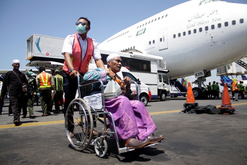 Petugas medis merawat seorang jamaah haji yang mengalami sakit saat tiba di tanah air di Bandara Internasional Juanda Surabaya di Sidoarjo, Jawa Timur, Minggu (18/9).