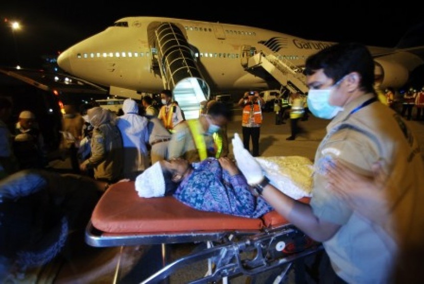 Petugas medis merawat seorang jemaah haji yang mengalami sakit jantung, saat tiba di Bandara Internasional Minangkabau (BIM), Padangpariaman, Sumatera Barat, Selasa (29/9).
