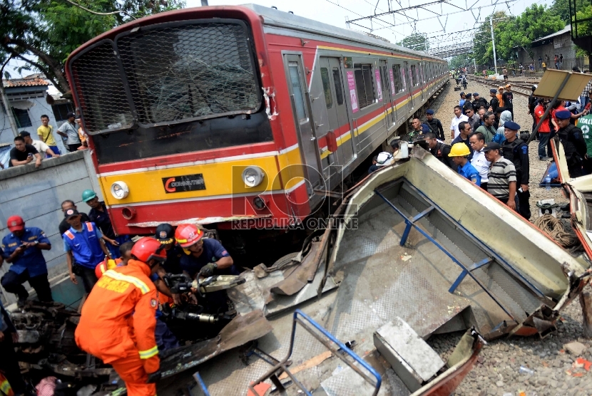 Petugas melakukan evakuasi bangkai Bus Metromini pascatabrakan dengan KRL di Kawasan Stasiun Angke, Jakarta Barat, Ahad (6/12).  (Republika/WIhdan)
