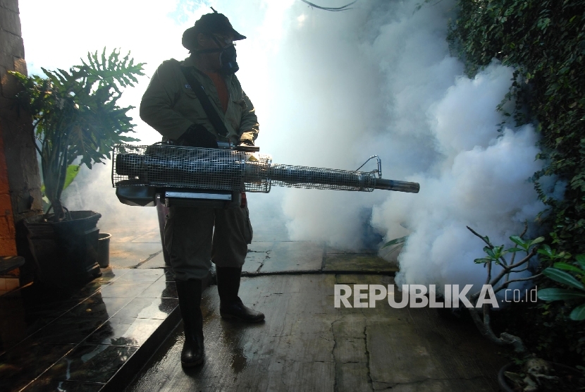 Petugas melakukan fogging atau pengasapan di areal pemukiman Cawang, Jakarta Timur, Selasa (5/2). 