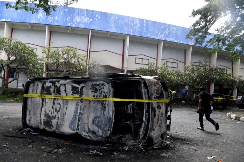 Petugas melakukan olah tempat kejadian perkara kerusuhan di Stadion Kanjuruhan, Malang, Jawa Timur, Ahad (2/10/2022). Sedikitnya 129 orang dilaporkan meninggal dunia dan 13 mobil rusak akibat kerusuhan tersebut.