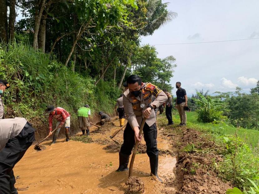 Petugas melakukan pembersihan badan jalan yang tertimpa material longsor di Kecamatan Ciawi, Kabupaten Tasikmalaya, Kamis (26/11). 