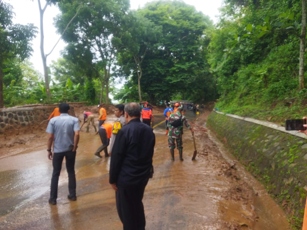 Petugas melakukan pembersihan material longsor di ruas jalan penghubung Majalengka – Kuningan via Cikijing, Kabupaten Majalengka, Kamis (16/1/2025) pagi. 