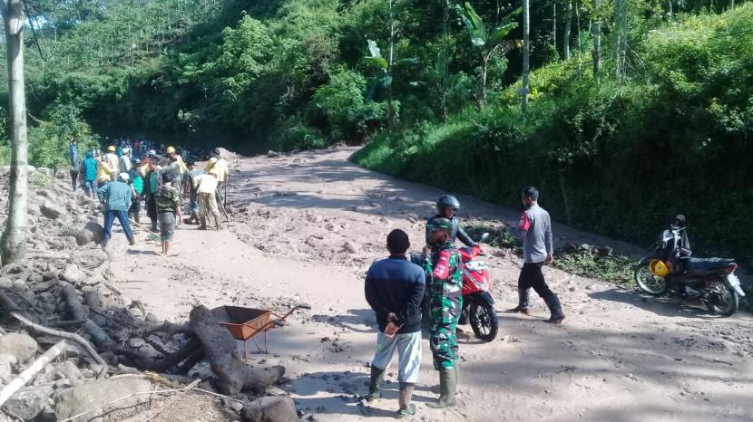 Petugas melakukan pembersihan material longsor yang menutup badan Jalan Raya Rancasalak, Kecamatan Kadungora, Kabupaten Garut, Kamis (25/3). 