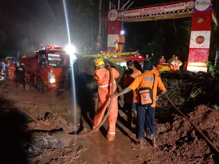 Petugas melakukan pembersihan material tanah longsor yang menutup akses jalan di Desa Puspahiang, Kecamatan Puspahiang, Kabupaten Tasikmalaya, Ahad (13/11/2022) malam. 