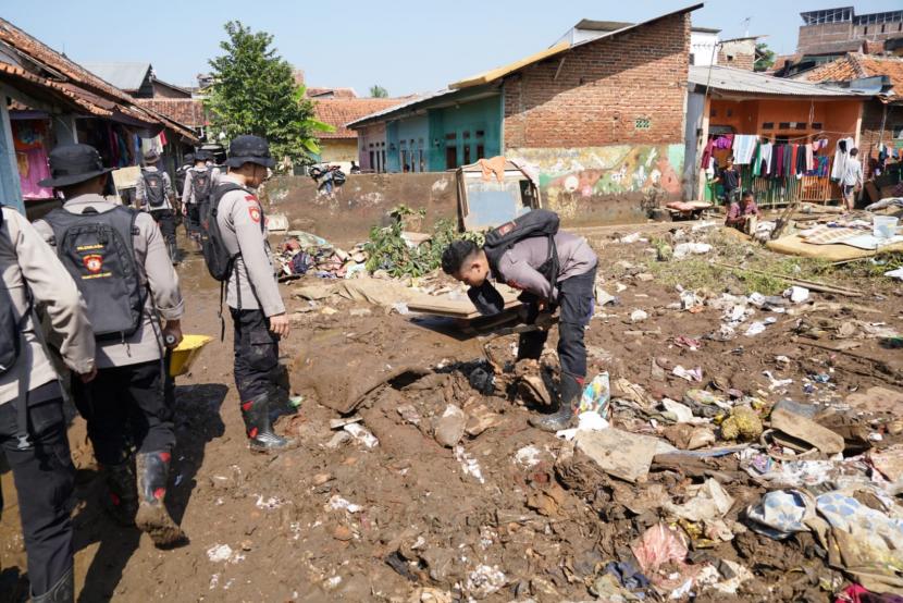 Petugas melakukan pembersihan material yang terbawa banjir bandang di Kampung Cimacan, Desa Haurpanggung, Kecamatan Tarogong Kidul, Kabupaten Garut, Rabu (20/7/2022). 