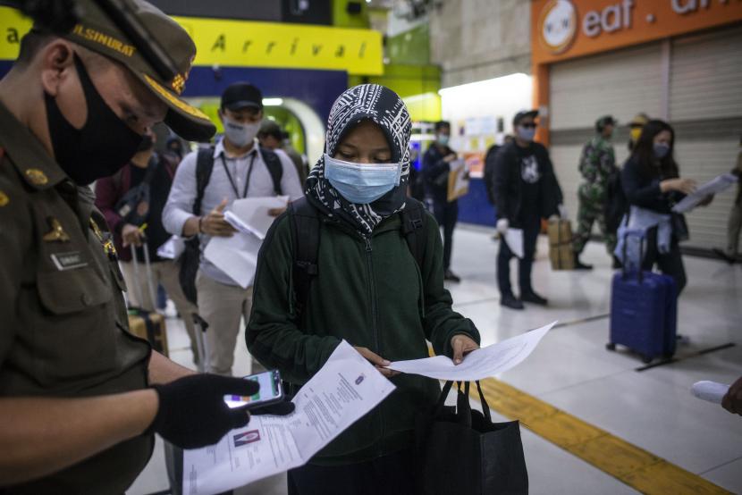 Petugas melakukan pemeriksaan dokumen penumpang Kereta Api Luar Biasa (KLB) Gambir-Surabaya Pasarturi saat tiba di Stasiun Gambir, Jakarta, Selasa (26/5).