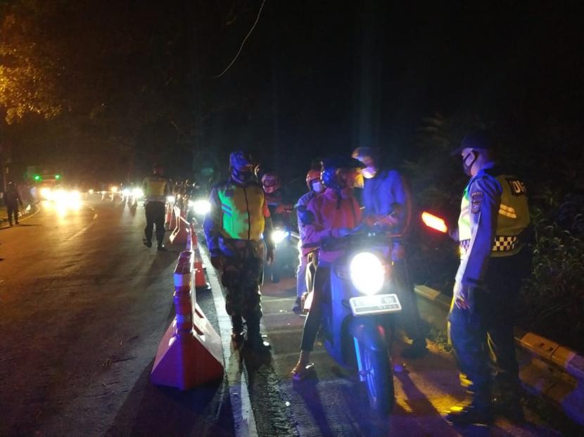 Petugas melakukan pemeriksaan pada kendaraan yang melintas di Jalur Gentong, Kabupaten Tasikmalaya, Rabu (12/5) malam