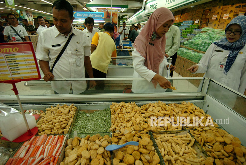 Petugas melakukan pemeriksaan saat razia makanan dan minuman di sebuah tempat perbelanjaan di Tegal, Jawa Tengah, Rabu (23/5).