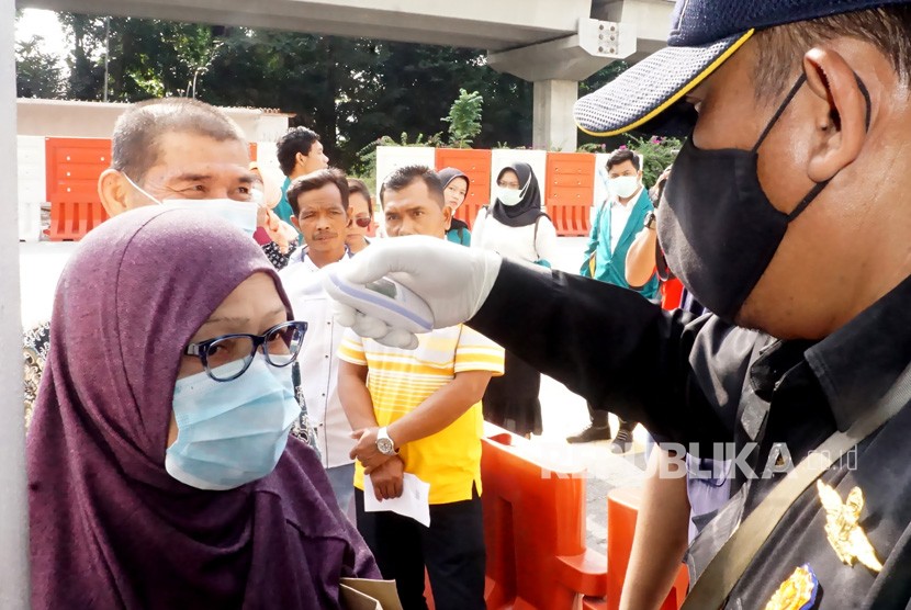 Petugas melakukan pemeriksaan suhu tubuh kepada tamu dan WNI yang berkunjung ke Kedutaan Besar Republik Indonesia (KBRI) Kuala Lumpur, Malaysia, Kamis (5/3/2020).(Antara/Agus Setiawan)