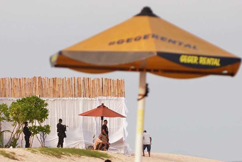 Petugas melakukan pengamanan wilayah pantai yang ditutup dengan pagar bambu di kompleks Hotel St Regis, Nusa Dua, Bali, Senin (6/3). 