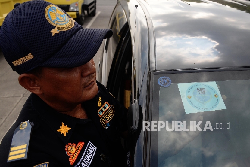 Petugas melakukan pengecekan saat uji uji kendaraan bermotor (KIR) Taksi berbasis aplikasi daring (online) di Pengelola Pengujian Kendaraan Bermotor, Pulo Gadung, Jakarta Timur, Senin (1/8). (Republika/Yasin Habibi)