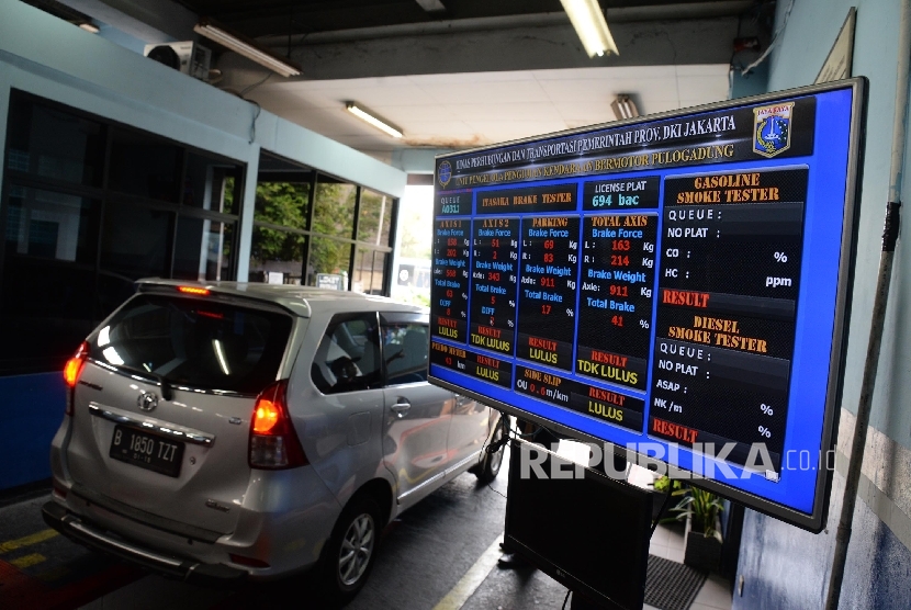 Petugas melakukan pengecekan saat uji uji kendaraan bermotor (KIR) Taksi berbasis aplikasi daring (online) di Pengelola Pengujian Kendaraan Bermotor, Pulo Gadung, Jakarta Timur, Senin (1/8).(Republika/Yasin Habibi)