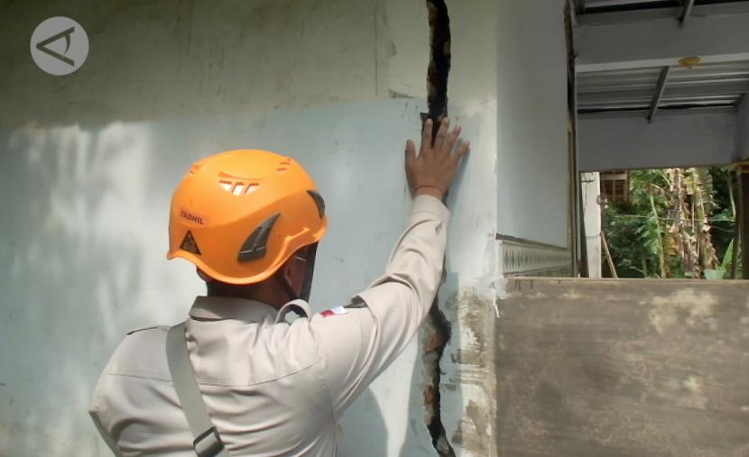 Petugas melakukan pengecekan terharap rumah yang terdampak pergerakan tanah di Jember, Jawa Timur.