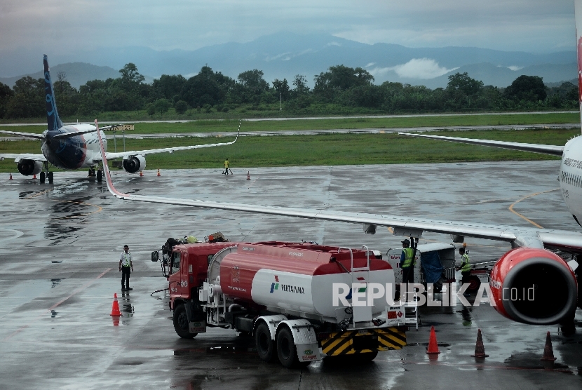 Petugas melakukan pengisian bahan bakar avtur milik pertamina pada salah satu pesawat perusahaan penerbangan di Apron Bandara Internasional Sultan Hasanuddin, Sulsel, Selasa(21/3). 