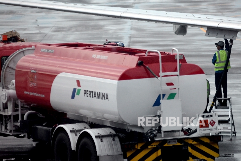 Petugas melakukan pengisian bahan bakar avtur milik pertamina pada salah satu pesawat perusahaan penerbangan di bandara. ilustrasi
