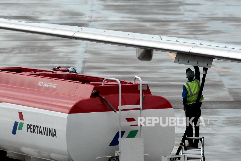 Petugas melakukan pengisian bahan bakar avtur milik pertamina pada salah satu pesawat perusahaan penerbangan di Apron Bandara Internasional Sultan Hasanuddin, Sulsel, Selasa(21/3).