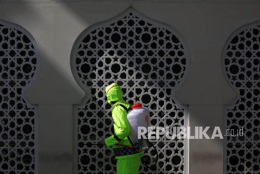 DMI Berharap Kasus Jamaah Masjid Kebon Jeruk Jadi Pelajaran. Petugas melakukan penyemprotan cairan disinfektan di komplek masjid.