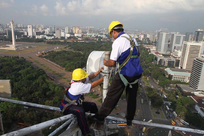 Petugas melakukan perawatan berkala pemancar Indosat, Jakarta, Senin (23/6).