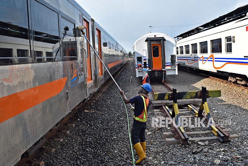 Petugas melakukan perawatan salah satu rangkaian kereta api penumpang.
