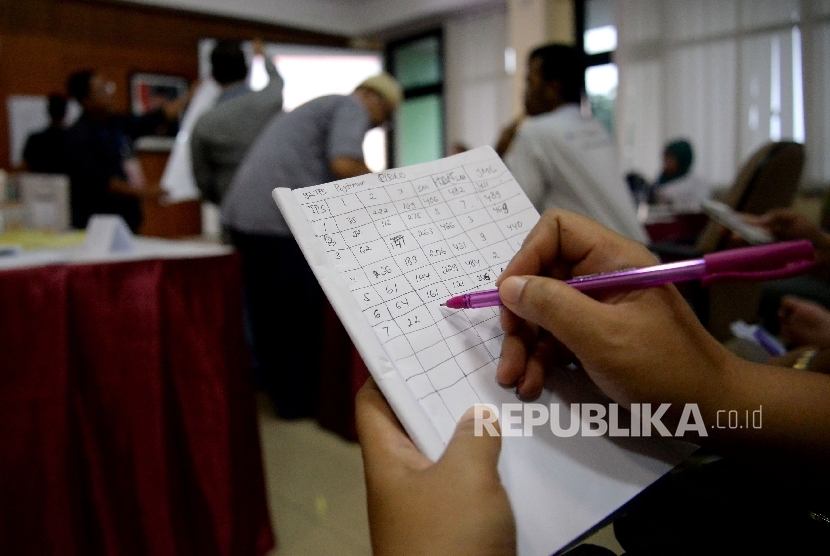 Petugas melakukan proses rekapitulasi penghitungan surat suara Pilkada DKI Jakarta tingkat kecamatan di Kantor Kecamatan Pasar Minggu, Jakarta, Kamis (16/2).