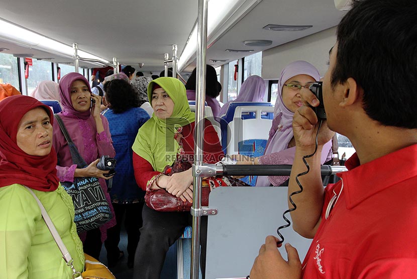 Petugas melakukan sosialisasi kepada penumpang saat uji coba bus wisata di Jakarta, Jumat (21/2).