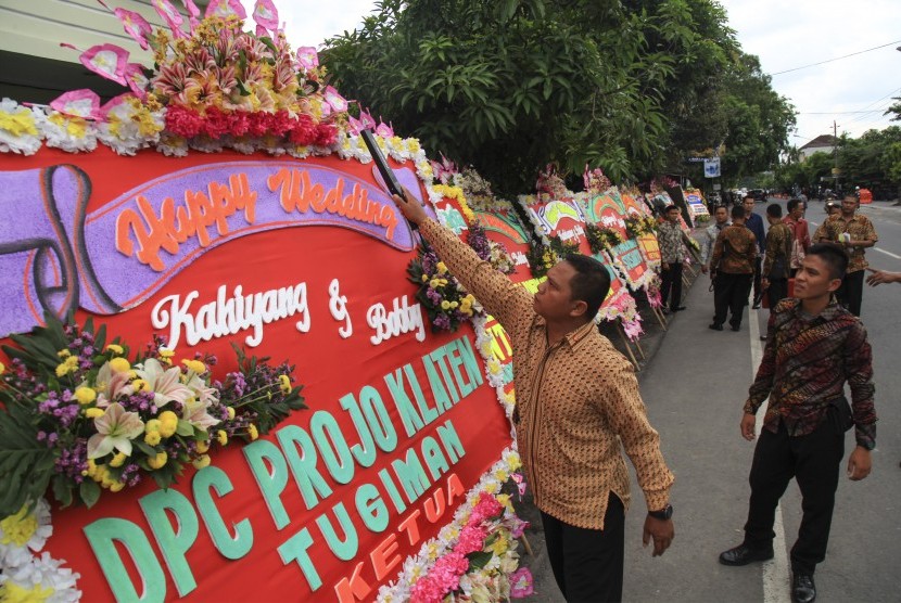Petugas melakukan sterilisasi karangan bunga untuk pernikahan putri Presiden Joko Widodo, Kahiyang Ayu (kanan) dengan Bobby Nasution (kiri) di Gedung Graha Saba, Solo, Jawa Tengah, Senin (6/11). 