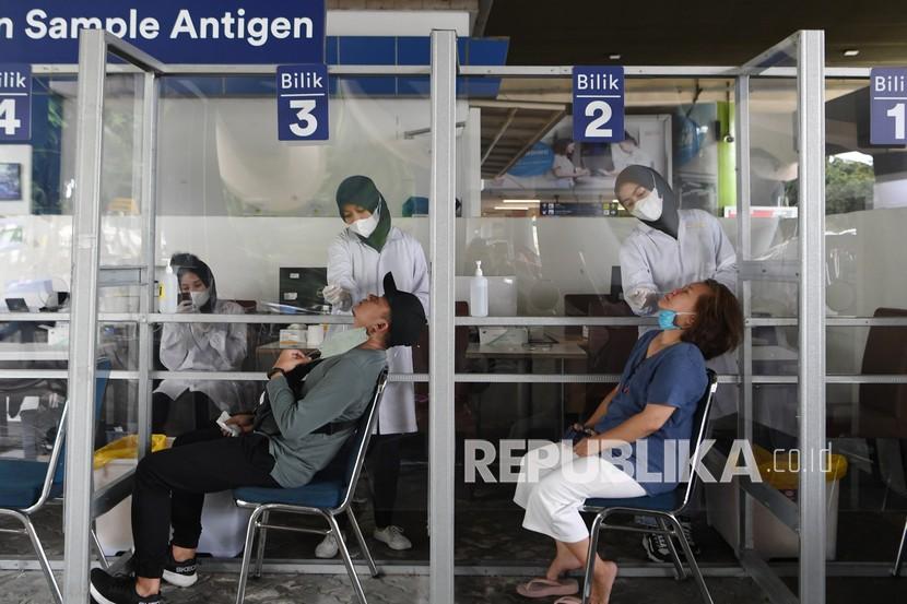 Petugas melakukan swab test antigen kepada calon penumpang kereta api di Stasiun Gambir, Jakarta, Ahad (2/1/2022). Pelaku perjalanan domestik.
