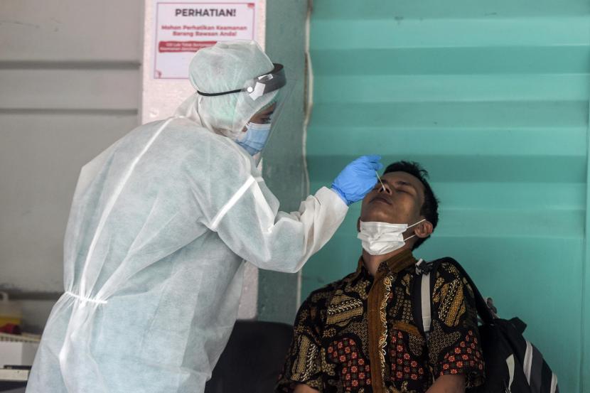 Petugas melakukan tes PCR kepada warga di GSI Lab, Jakarta.