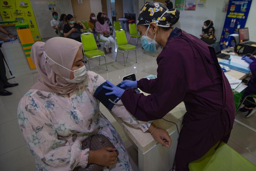 IMF: 2021, Tahun Penentuan Fondasi Ekonomi Abad 21. Petugas melakukan tes skrining terhadap calon penerima vaksin COVID-19 produksi Sinovac saat kegiatan vaksinasi massal dosis pertama di Puskesmas Kecamatan Sawah Besar, Jakarta Pusat, Ahad (7/2/2021). Kementerian Kesehatan hingga Minggu (7/2) telah memberikan vaksin COVID-19 Sinovac tahap pertama kepada 784.318 orang, sementara untuk vaksinasi tahap kedua sudah diberikan kepada 139.131 orang