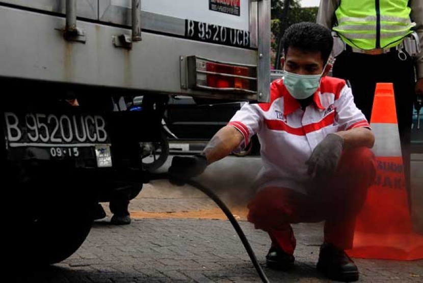 Petugas melakukan uji asap dari kendaraan pribadi saat pelaksanaan uji emisi gratis di kawasan Tugu Proklamasi, Jakarta.