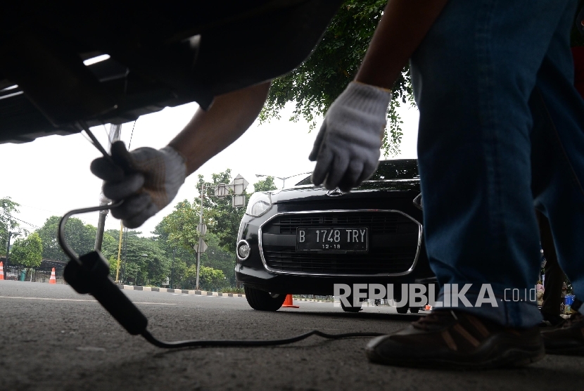 Petugas melakukan uji emisi gas buang pada kendaraan roda empat yang melintas di Jalan Pemuda, Jakarta Timur, Selasa (26/4). (Republika / Yasin Habibi)