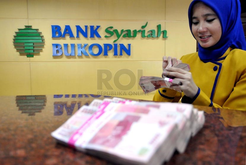 Petugas melayani nasabah di banking hall salah satu kantor cabang Bank Syariah Bukopin di Jakarta, Selasa (25/3).