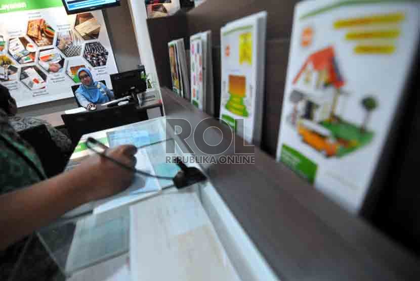  Petugas melayani nasabah di kantor layanan BNI Syariah, Jakarta, Selasa (19/8). (Republika/ Wihdan)