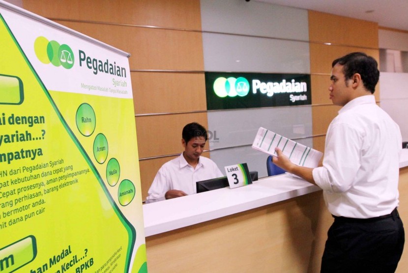 Petugas melayani nasabah di kantor Pegadaian Syariah, Jakarta, Senin (8/12).