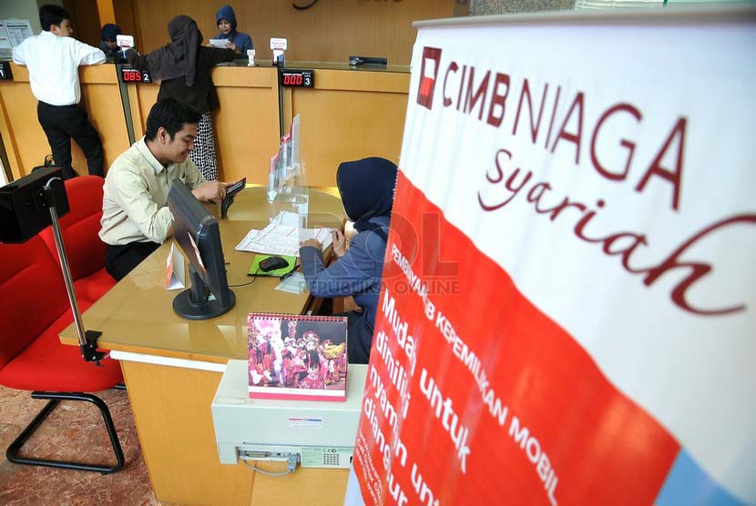 Petugas melayani nasabah di salah satu kantor cabang Bank CIMB Niaga Syariah, Jakarta, Senin (14/7). 