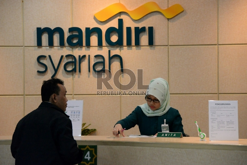 Petugas melayani nasabah di salah satu kantor cabang Bank Syariah Mandiri, Jakarta, Jumat (13/2).