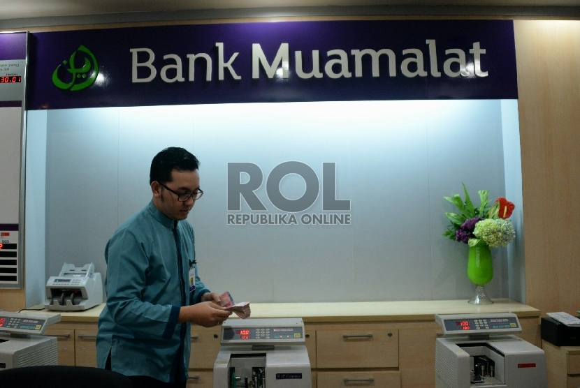 Petugas melayani nasabah di salah satu kantor cabang Bank Muamalat, Jakarta, Selasa (10/3).