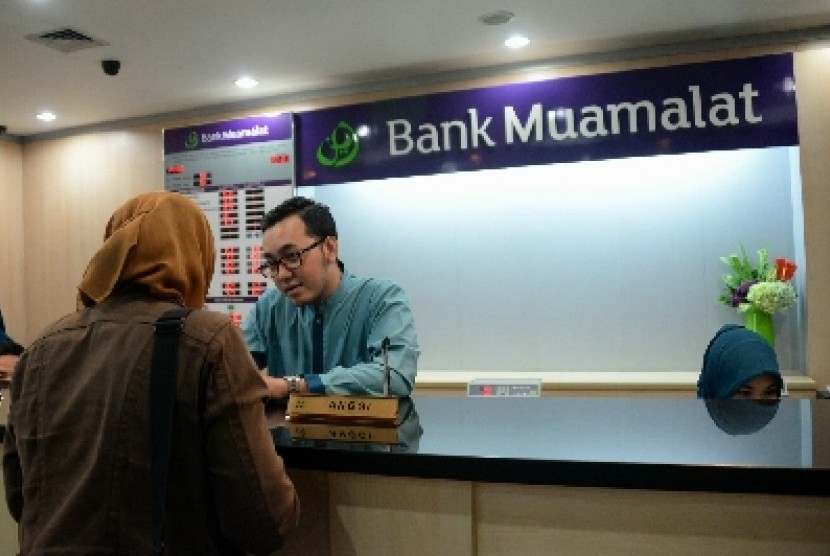 Petugas melayani nasabah di salah satu kantor cabang Bank Muamalat, Jakarta, Selasa (10/3).