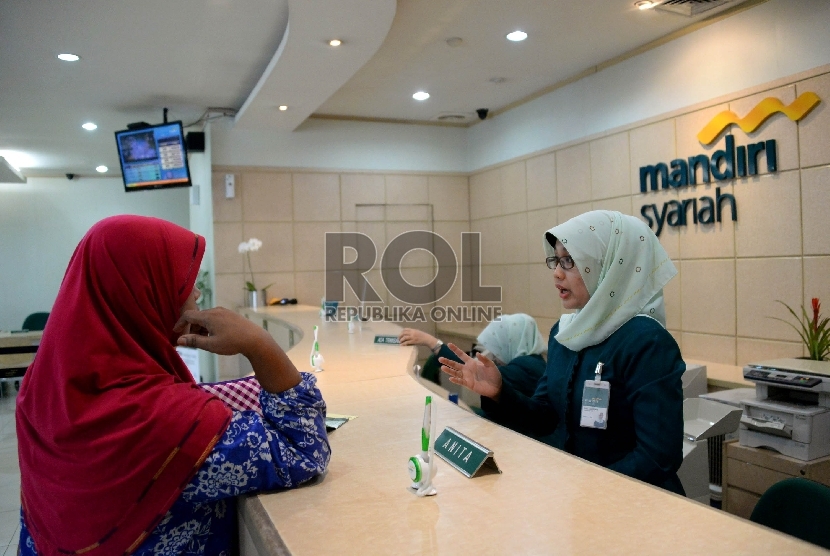 Petugas melayani nasabah di salah satu kantor cabang Bank Syariah Mandiri, Jakarta, Kamis (21/5).