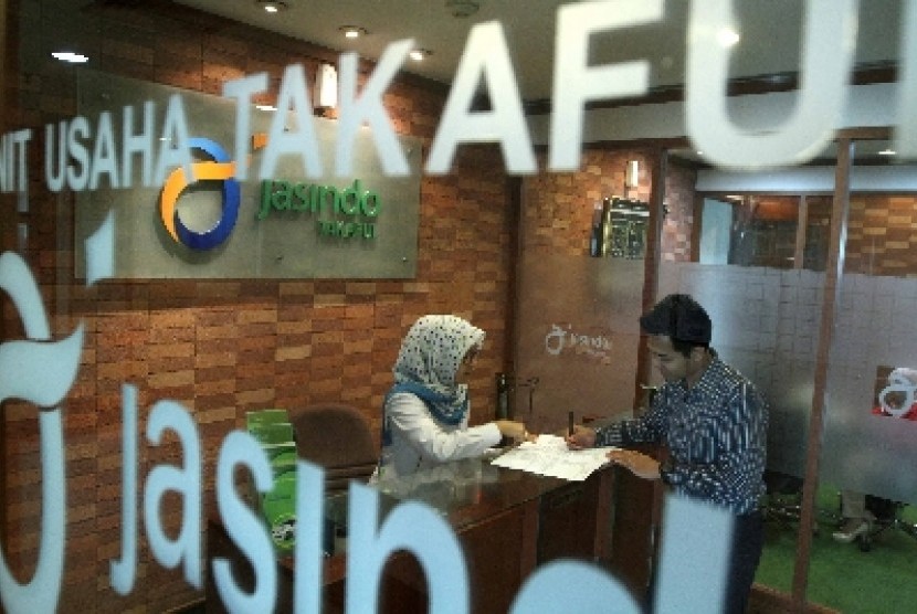 Petugas melayani nasabah di salah satu kantor Jasindo Takaful, Jakarta, Selasa (24/6). 