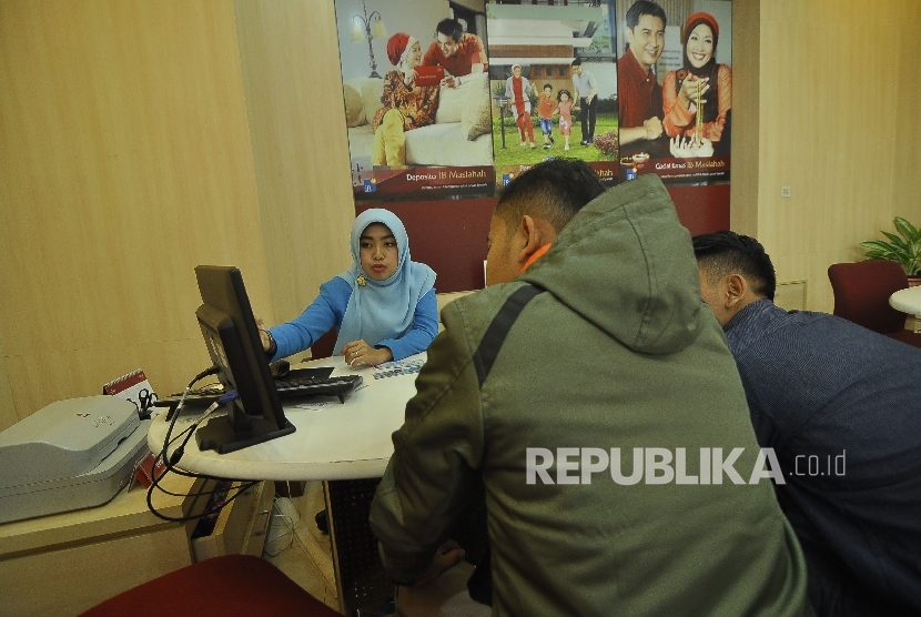 Petugas melayani nasabah di salah satu kantor pelayanan Bank BJB Syariah, Jalan Braga, Kota Bandung, Selasa (18/4).