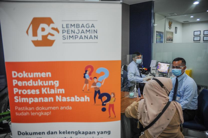 Petugas melayani nasabah yang mencairkan pengembalian dana dari Bank yang telah dilikuidasi di teller Bank Mandiri, Bandung, Jawa Barat, Jumat (29/1/2021). Lembaga Penjamin Simpanan (LPS) telah membayar simpanan nasabah bank yang dilikuidasi sebesar Rp 1,69 triliun sepanjang 2005-2021.