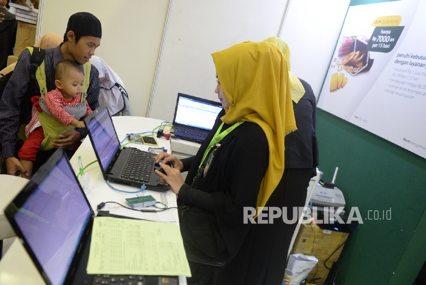  Petugas melayani nasbah di kantor layanan Bank Syariah Mandiri, Jakarta, Ahad (7/5)