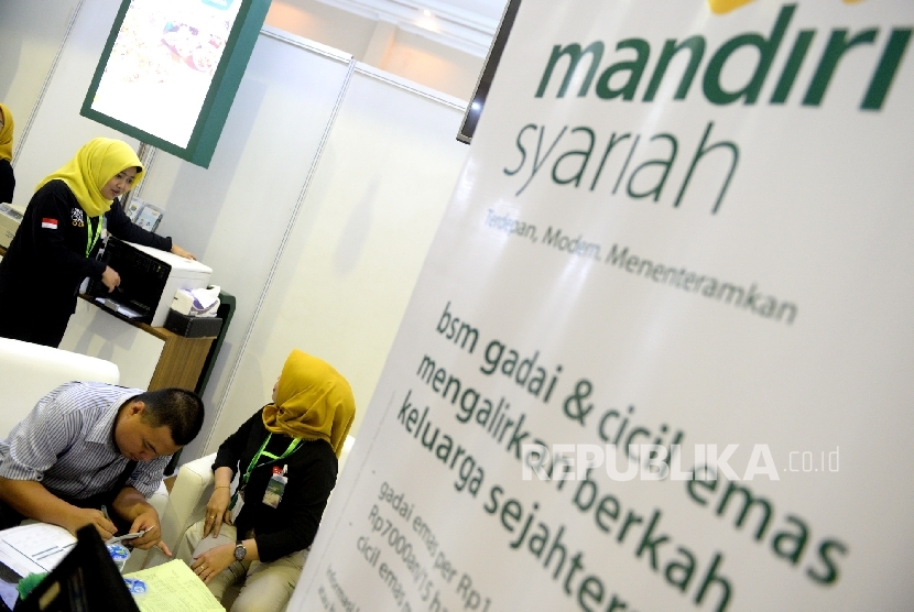 Petugas melayani nasabah di kantor layanan Bank Syariah Mandiri, Jakarta, Ahad (7/5).